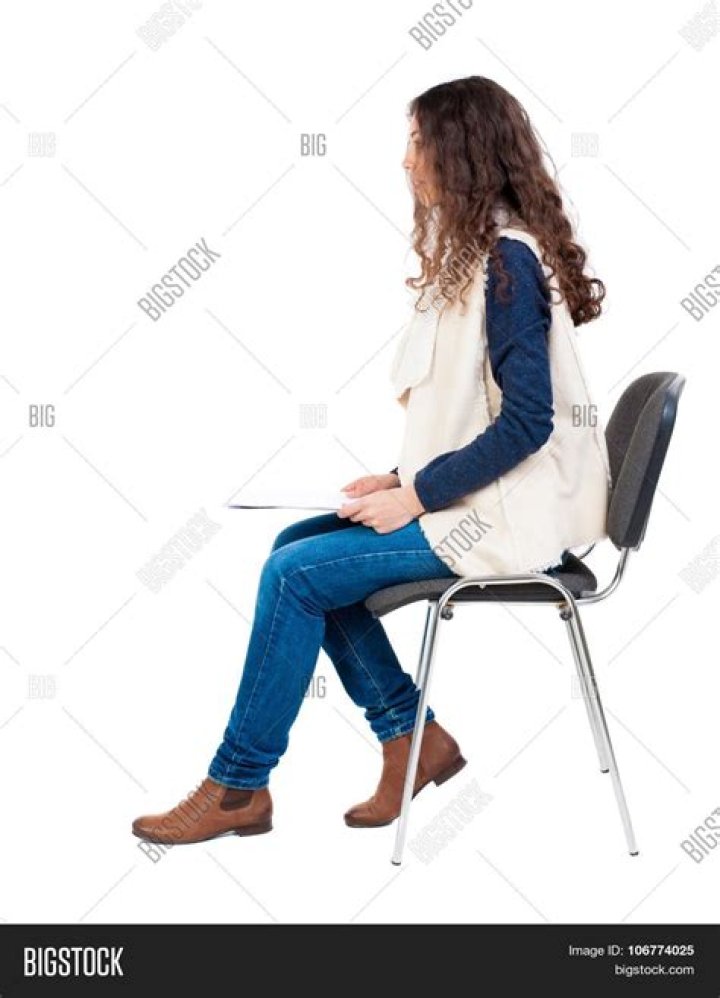 a woman sitting on the floor looking at her cell phone and taking a selfie