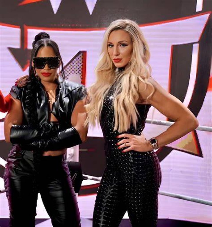 bianca belair with charlotte flair on her shoulders