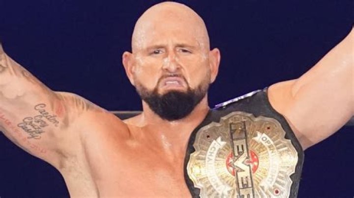 karl anderson with his arms raised