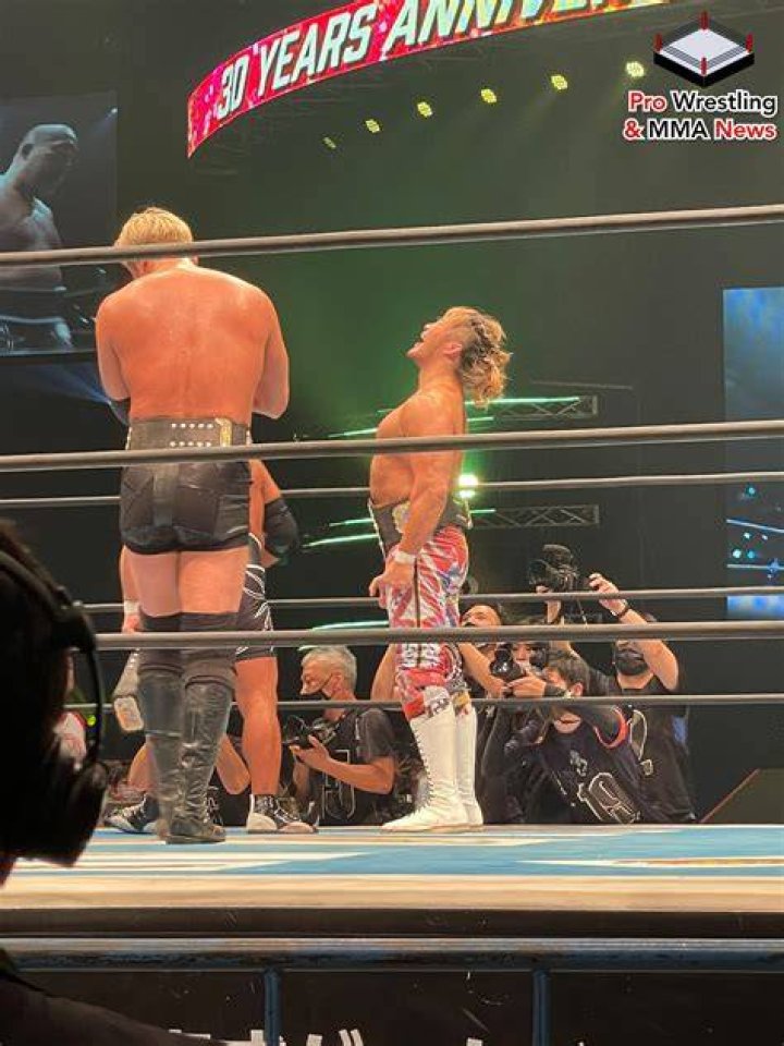 Okada, Ishii, and Tanahashi with their arms raised. 
