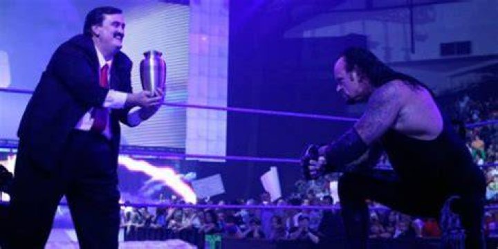 Paul Bearer controlling The Undertaker with the urn