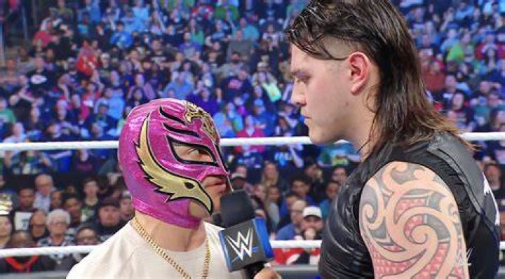 Rey Mysterio is getting slapped by Dominik Mysterio
