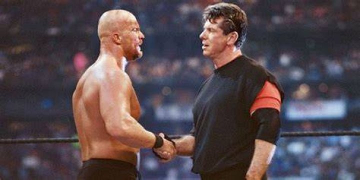 Steve Austin shaking hands with Vince McMahon. 