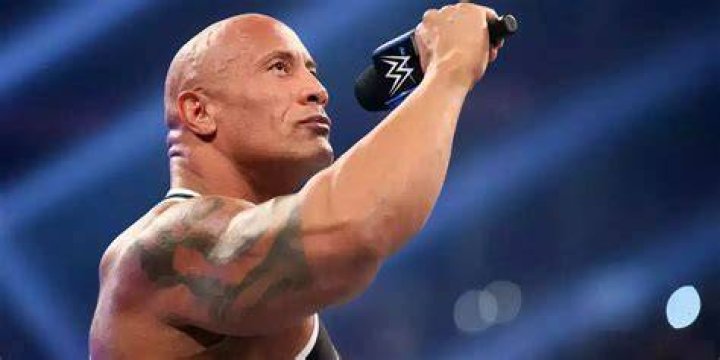 The Rock holding a microphone