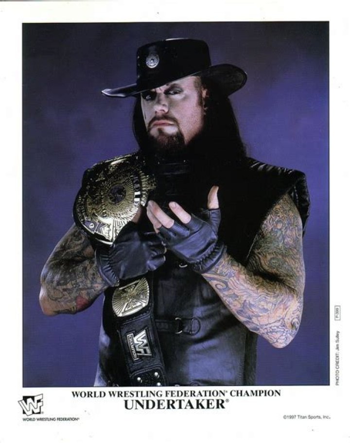 The Undertaker holding the winged eagle WWE Championship. 