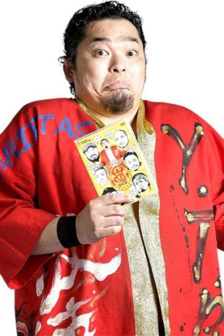 Toru Yano and The Briscoes posing in front of a green screen.